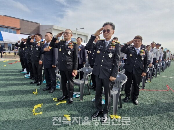 자율방범대 임원들이 국민의례에서 국기에 대한 경례를 엄숙히 하고 있다